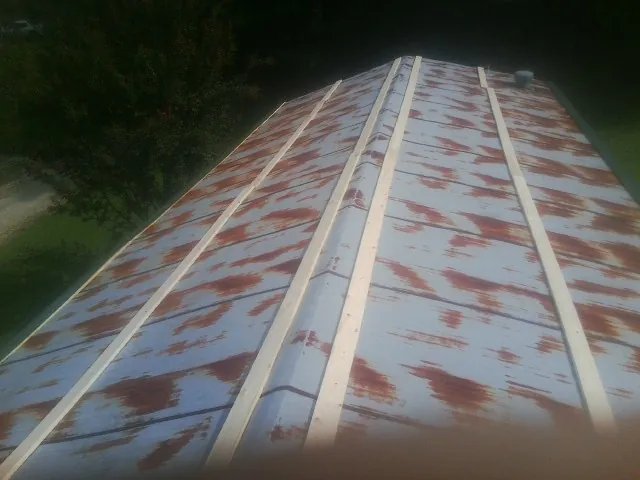 Rusted metal roof panels with new wood purlins before replacement — Storm Damage Roof Repair in Apollo by Roofing Brothers