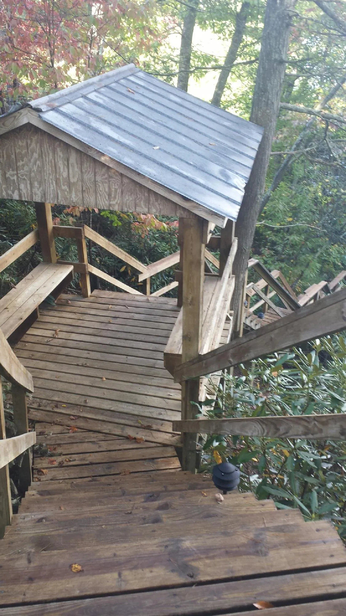Metal roofed shelter over wooden steps on a wooded walkway — Skylight Repair & Installation work by our crew in Apollo