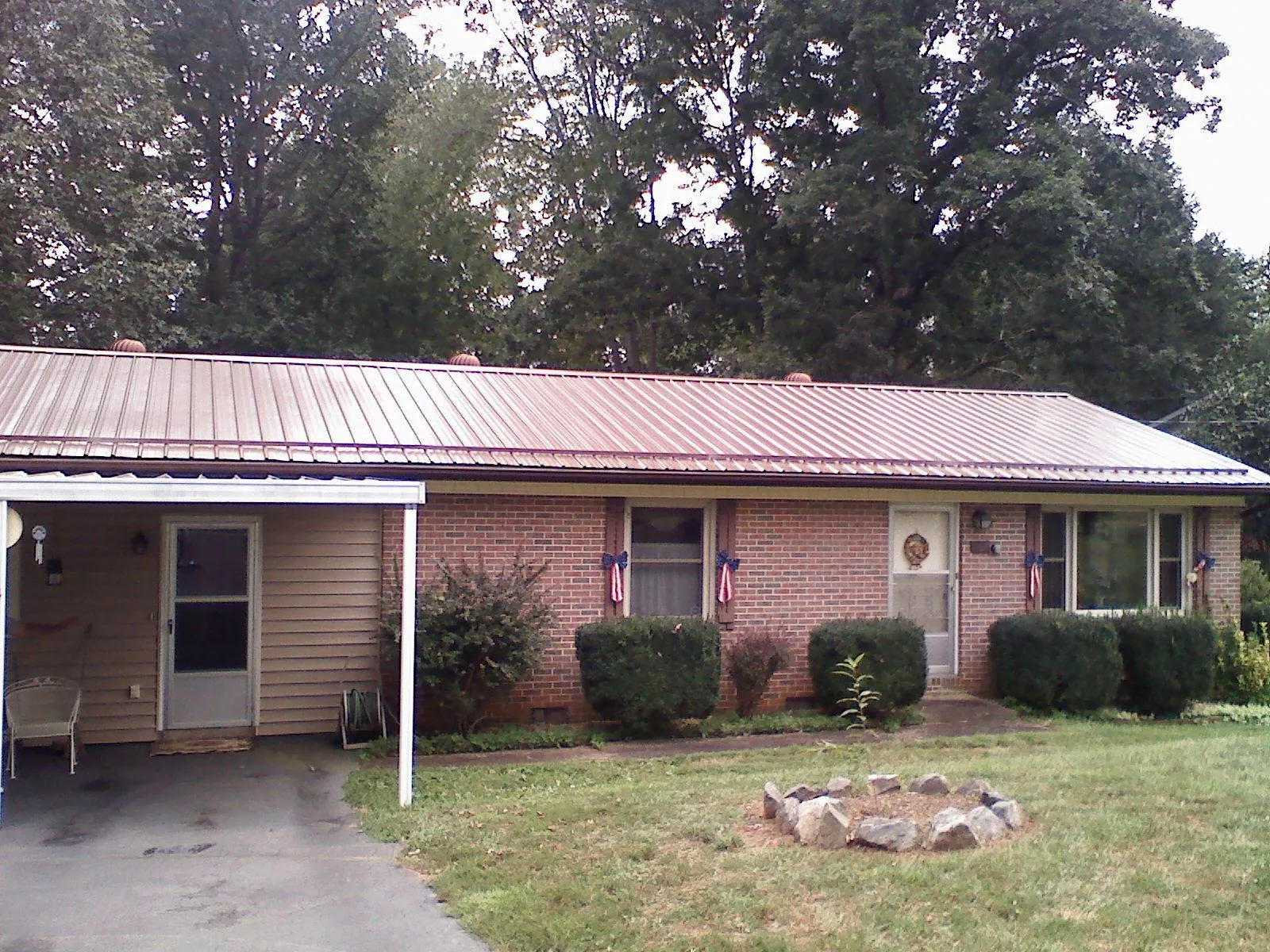 Bronze metal roof and carport on a brick ranch home — Roof Repair work by our crew in Apollo